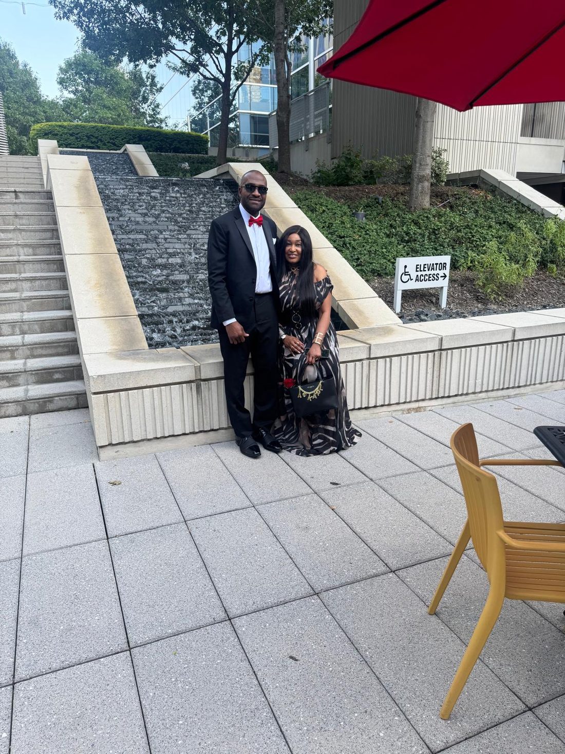 Conrad in a tuxedo and Lilian in a flowing gown beside a fountain